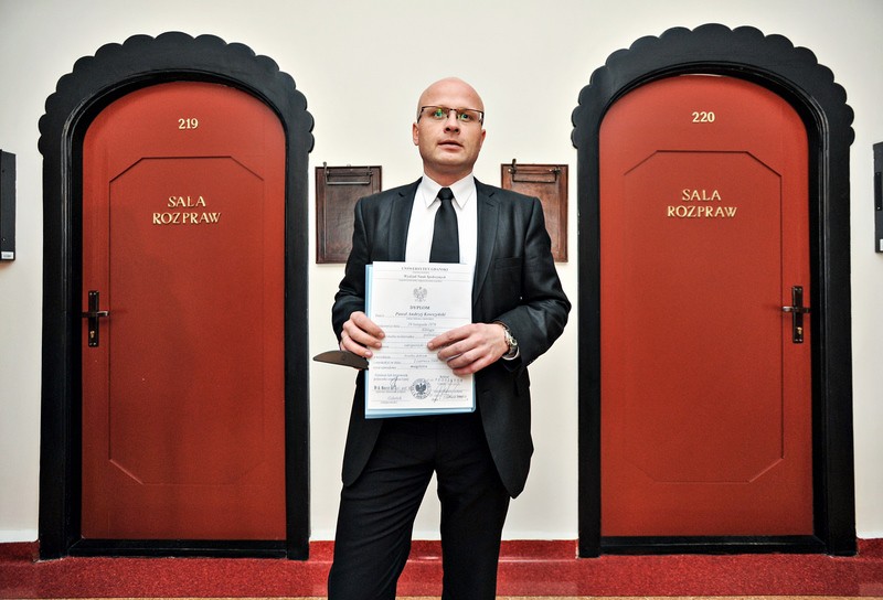 Elbląg, Paweł Kowszyński prezentuje dyplomy świadczące o ukończonych studiach Elbląg, Paweł Kowszyński prezentuje dyplomy świadczące o ukończonych studiach