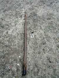 Z metalową rurą na policjanta