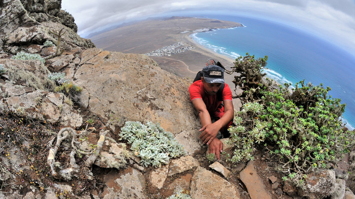 NA RISCO DE FAMARA -  w tle widoczna plaża Famara. Wspinaczka na wielkim klifie wulkanicznej wyspy Lanzarote. (Sierpień 2013)