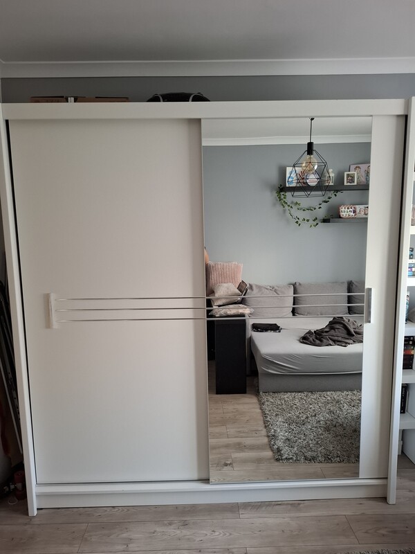 Elbląg Nowoczesna, biała szafa z kolekcji Agata Meble. Posiada dwie przesuwne drzwi, które zapewniają wygodny dostęp