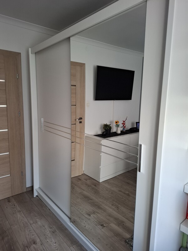 Elbląg Nowoczesna, biała szafa z kolekcji Agata Meble. Posiada dwie przesuwne drzwi, które zapewniają wygodny dostęp