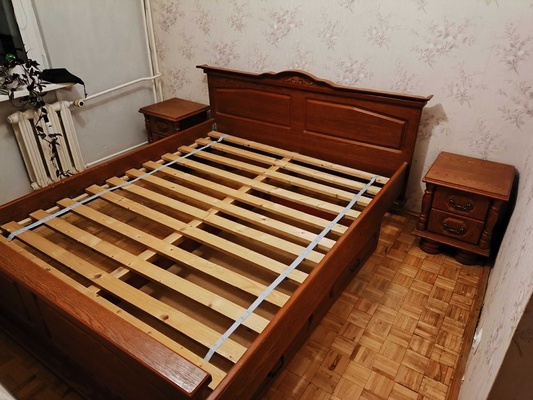 Elbląg Drewniane łóżko z szufladą i dwoma szafkami nocnymi. Mebel jest w dobrym stanie, wykonany z solidnego drewna.
