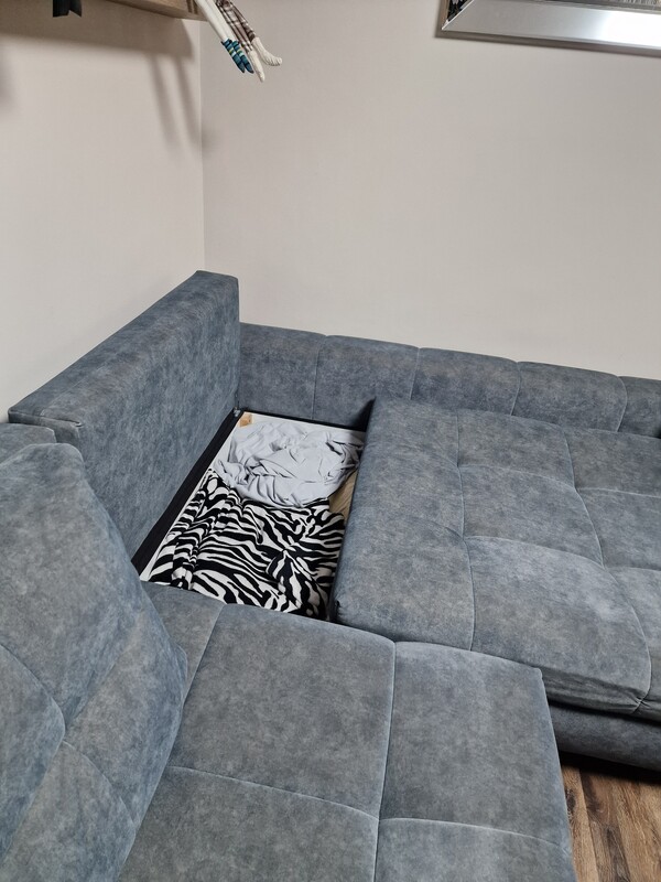 Elbląg Lewy kompaktowy narożnik PICOLLO z funkcją spania z przyjemnej tkaniny w kolorze ciemnej, zgaszonej zieleni.