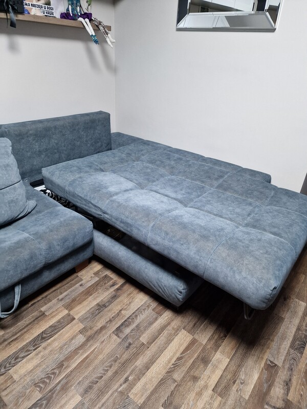 Elbląg Lewy kompaktowy narożnik PICOLLO z funkcją spania z przyjemnej tkaniny w kolorze ciemnej, zgaszonej zieleni.