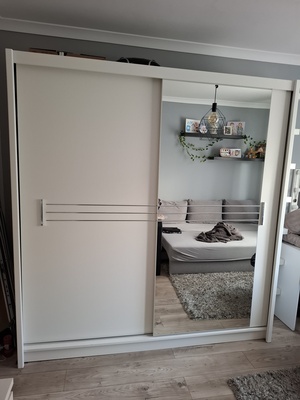 Elbląg Nowoczesna, biała szafa z kolekcji Agata Meble. Posiada dwie przesuwne drzwi, które zapewniają wygodny dostęp