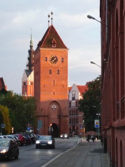 Oświetlone wieże. Brama Targowa i Katedra św. Mikołaja u schyłku dnia (Sierpień 2018)