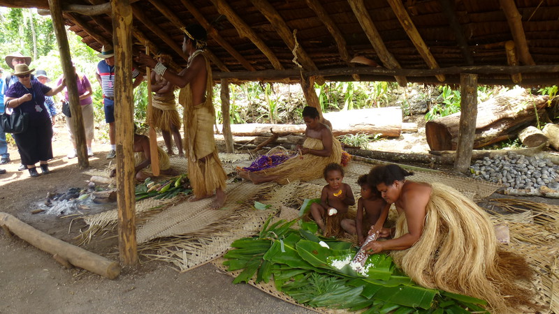 Kobiety przyrządzają tradycyjne posiłki z owoców typu banan, mango, chlebowiec. Kobieta zajmuje się również dziećmi